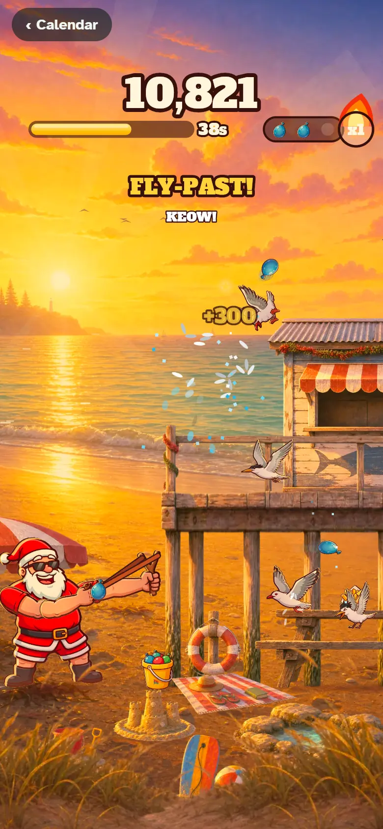 Santa flings water bombs at seagulls on a beach jetty at sunset while a gull flies past for bonus points.